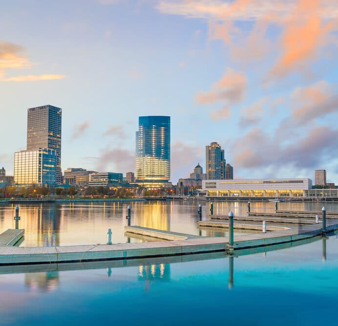 Milwaukee skyline at twilight with city reflection in Lake Michigan.
