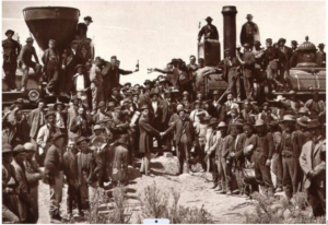 Union Pacific and Central Pacific locomotives meet at Promontory Summit, Utah, on May 10, 1869, as workers and officials celebrate completion of the first transcontinental railroad.